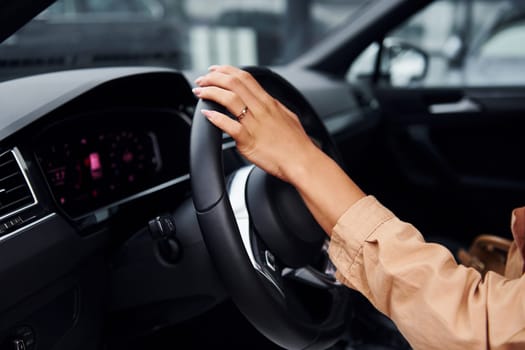 Driving car. Fashionable beautiful young woman and her modern automobile.