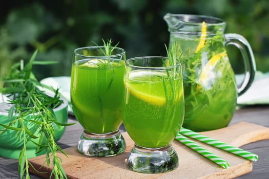 Homemade summer refreshing tarragon lemon drink on patio table.