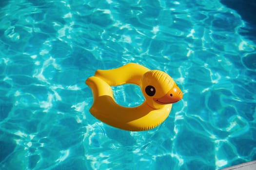 Top view of yellow duck toy for swimming in the pool at daytime.