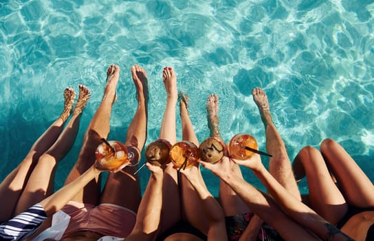 Top view of group of young happy people that have fun in swimming pool at daytime.