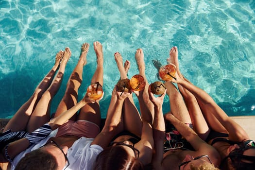 Top view of group of young happy people that have fun in swimming pool at daytime.