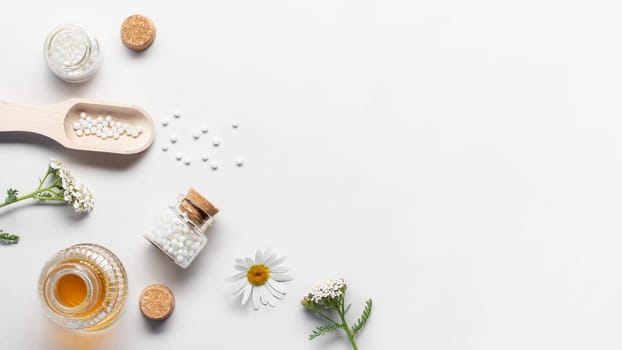 Homeopathic medicines and medicinal plants on a light background, copy space, flatlay.