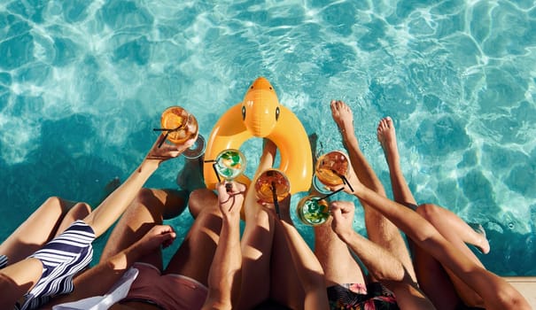 Top view of group of young happy people that have fun in swimming pool at daytime.