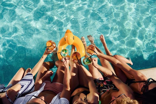 Top view of group of young happy people that have fun in swimming pool at daytime.