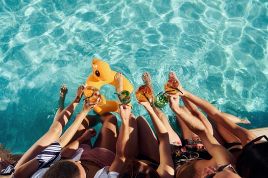 Top view of group of young happy people that have fun in swimming pool at daytime.