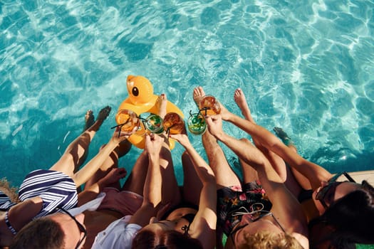 Top view of group of young happy people that have fun in swimming pool at daytime.