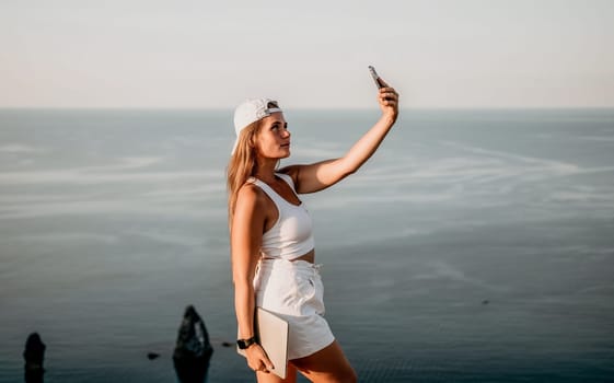 Woman travel sea. Young Happy woman in a long red dress posing on a beach near the sea on background of volcanic rocks, like in Iceland, sharing travel adventure journey