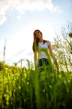 joyful woman posing in tall grass on a sunny day. High quality photo