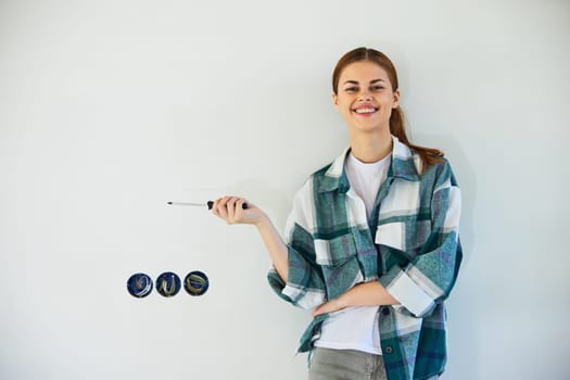 happy, smiling woman stands with a screwdriver and fixes sockets on a light wall. High quality photo