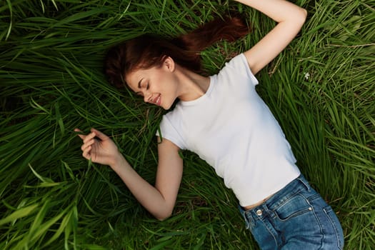 top view of a joyful woman lying in the grass. High quality photo