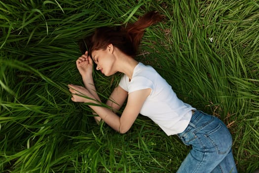 woman lies in tall grass falling asleep in nature. High quality photo