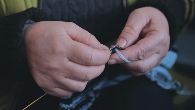 Grandma is knitting a blouse. Close-up of her hands