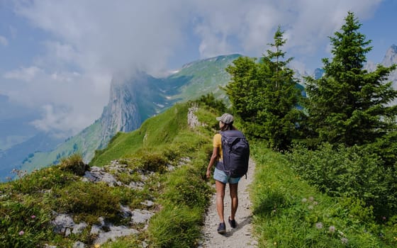 women hiking in the Swiss Alps mountains during summer vacation with a backpack and hiking boots. woman walking on the Saxer Lucke path