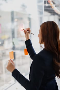 Beautiful young teen asian businesswoman using note pad thinking with planning working on financial document, tax, exchange, accounting and Financial advisor.