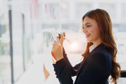 Beautiful young teen asian businesswoman using note pad thinking with planning working on financial document, tax, exchange, accounting and Financial advisor.