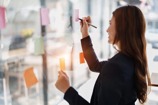 Beautiful young teen asian businesswoman using note pad thinking with planning working on financial document, tax, exchange, accounting and Financial advisor.