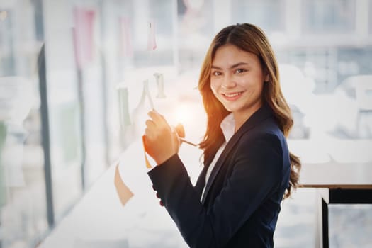 Beautiful young teen asian businesswoman using note pad thinking with planning working on financial document, tax, exchange, accounting and Financial advisor.