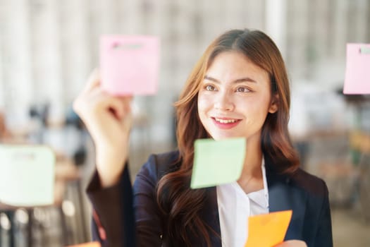 Beautiful young teen asian businesswoman using note pad thinking with planning working on financial document, tax, exchange, accounting and Financial advisor.