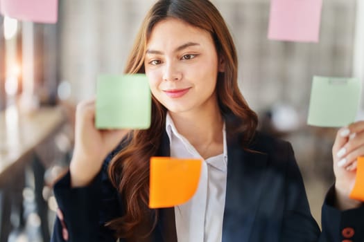 Beautiful young teen asian businesswoman using note pad thinking with planning working on financial document, tax, exchange, accounting and Financial advisor.