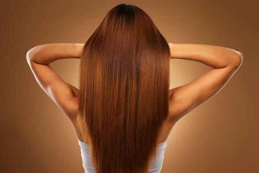 Back of hair, beauty and woman in studio for growth, wellness and keratin treatment on brown background. Hairdresser mockup, salon and girl with hairstyle for shampoo, haircare texture or cosmetics.