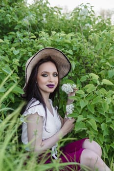 A fashionable girl with dark hair, a spring portrait in lilac tones in summer. Bright professional makeup