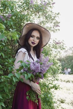 A fashionable girl with dark hair, a spring portrait in lilac tones in summer. Bright professional makeup