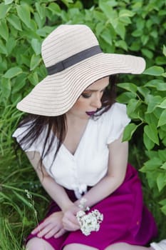 A fashionable girl with dark hair, a spring portrait in lilac tones in summer. Bright professional makeup