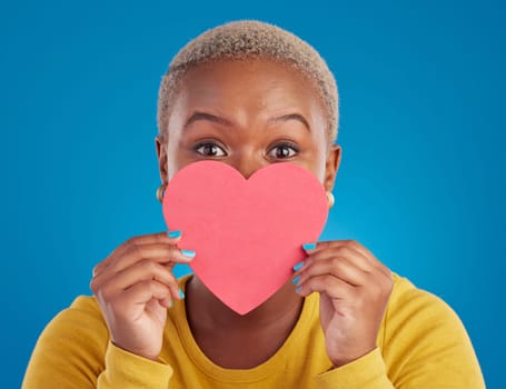 Paper, heart and shy with black woman in studio for love, date and kindness. Invitation, romance and feelings with female and shape isolated on blue background for emotion, support and affectionate.
