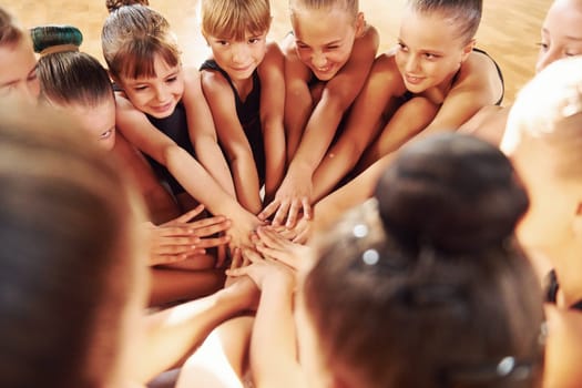 Many of people. Group of female kids practicing athletic exercises together indoors.