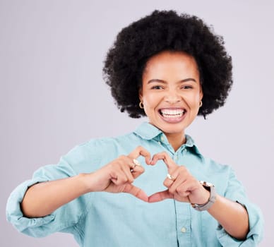 Black woman, studio portrait and heart hands with afro, smile and romance icon with love, confidence and face. Happy african, model and emoji for happiness, date and romantic sign by gray background.