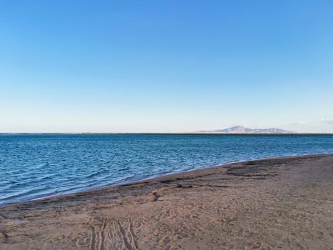 Sea coast on quiet day. Islands on the horizon. Quiet ocean water