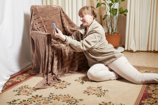 Adult woman with cell phone in room. Middle aged female customer holding smartphone using mobile app, texting message, search commerce offer on phone technology device at homes. Partial focus