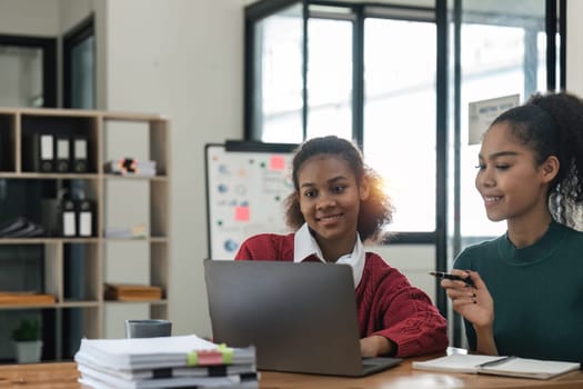 Young group of diverse students studying together using laptop at home. College multiracial people working on university group assignment homework project in modern apartment.