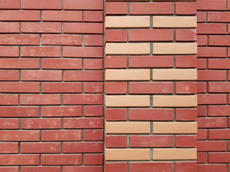 The modern texture of a red brick wall with a yellow brick ornament is the background material of industrial construction.