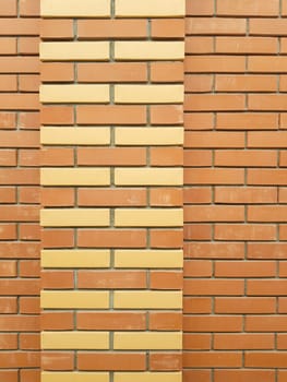 The modern texture of an orange brick wall with a yellow brick ornament is the background material of industrial construction.
