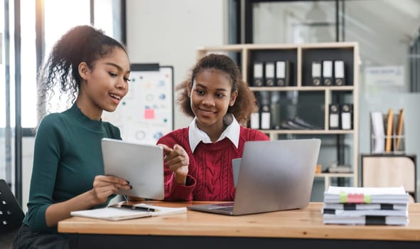 Young group of diverse students studying together using laptop at home. College multiracial people working on university group assignment homework project in modern apartment.