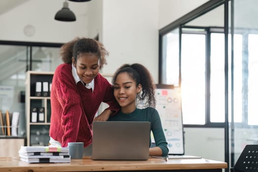 Young group of diverse students studying together using laptop at home. College multiracial people working on university group assignment homework project in modern apartment.