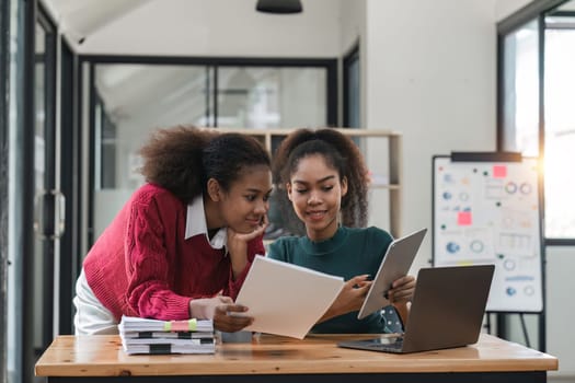 Young group of diverse students studying together using laptop at home. College multiracial people working on university group assignment homework project in modern apartment.