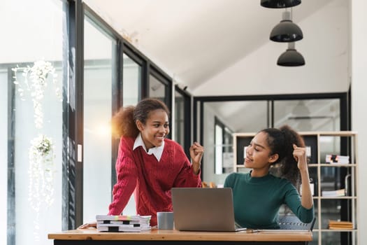 Young group of diverse students studying together using laptop at home. College multiracial people working on university group assignment homework project in modern apartment.