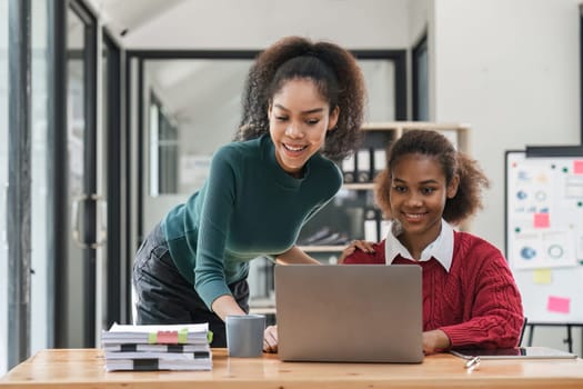 Young group of diverse students studying together using laptop at home. College multiracial people working on university group assignment homework project in modern apartment.