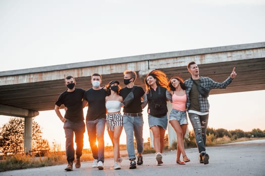 Embracing each other. Group of young cheerful friends having fun together. Party outdoors.