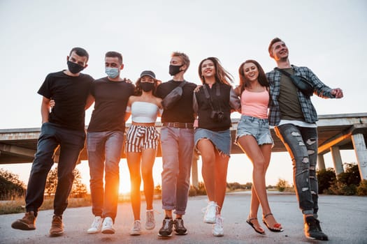 Embracing each other. Group of young cheerful friends having fun together. Party outdoors.