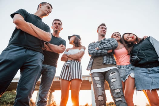 Posing for a camera. Group of young cheerful friends having fun together. Party outdoors.