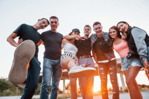 Embracing each other. Group of young cheerful friends having fun together. Party outdoors.