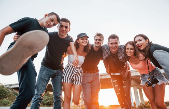 Posing for a camera. Group of young cheerful friends having fun together. Party outdoors.