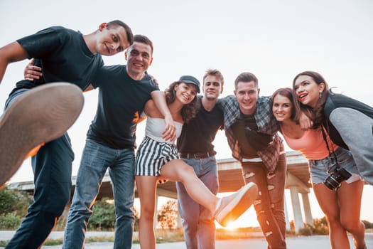 Posing for a camera. Group of young cheerful friends having fun together. Party outdoors.