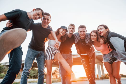 Posing for a camera. Group of young cheerful friends having fun together. Party outdoors.