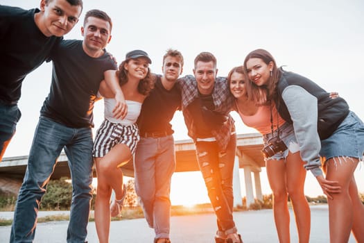 Posing for a camera. Group of young cheerful friends having fun together. Party outdoors.