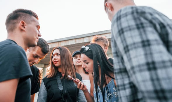 Talking and laughing. Group of young cheerful friends having fun together. Party outdoors.