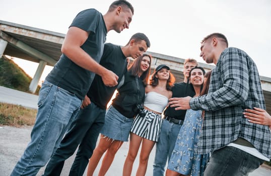 Talking and laughing. Group of young cheerful friends having fun together. Party outdoors.